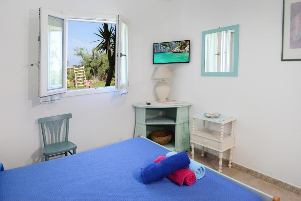 une chambre avec un lit, un bureau et une fenêtre dans l'établissement villa la Scaletta, à Alghero