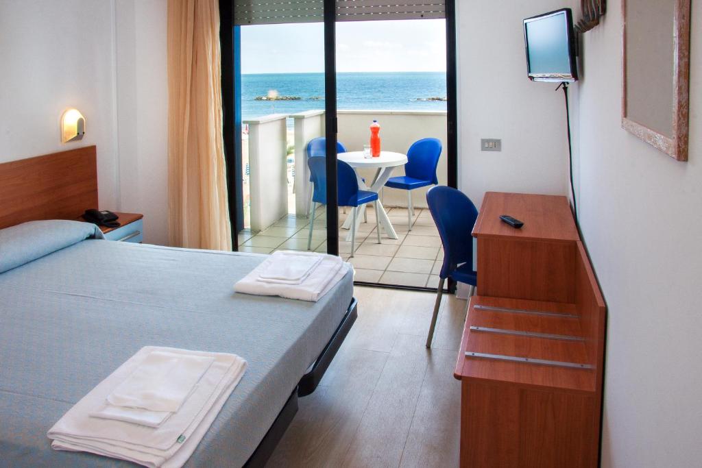 Cette chambre comprend un lit et une table avec vue sur l'océan. dans l'établissement Residence Sunrise, à San Benedetto del Tronto 77 autres photos