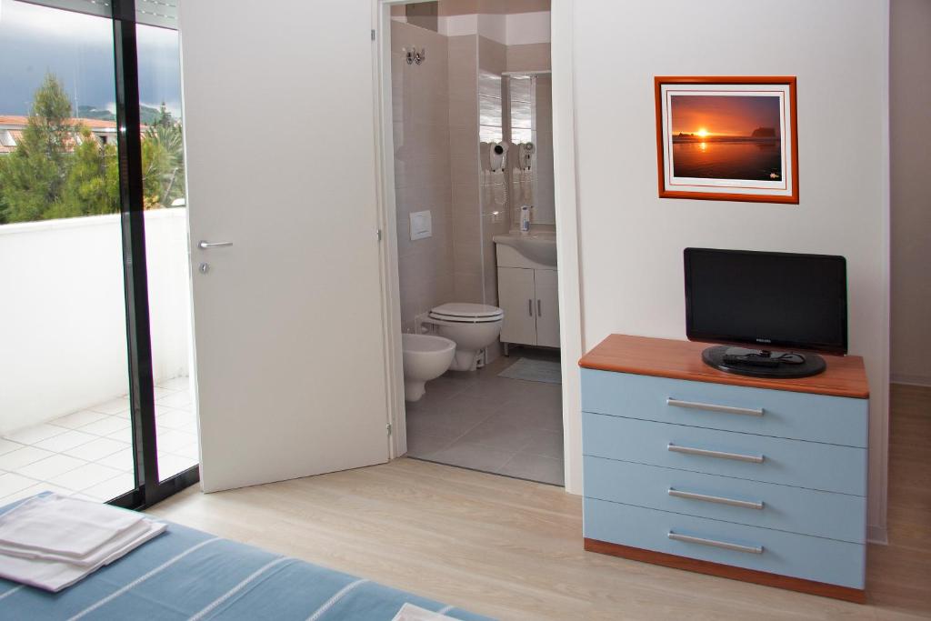 une chambre avec un lit et une télévision et une salle de bain dans l'établissement Residence Sunrise, à San Benedetto del Tronto