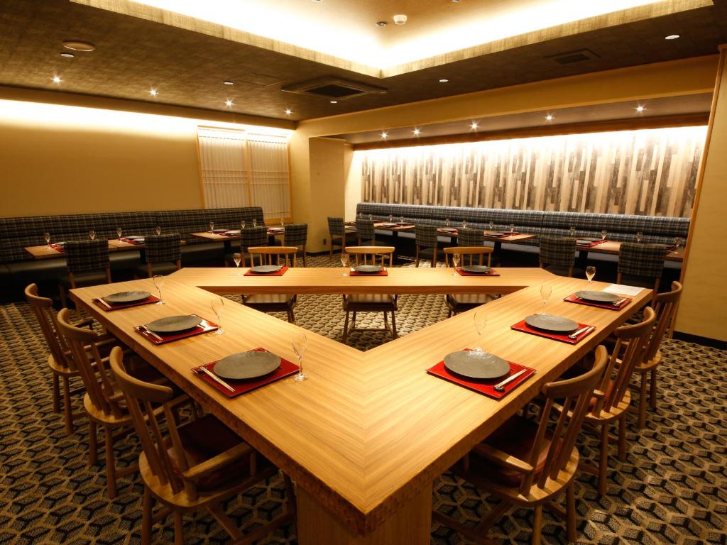 une salle de conférence avec une grande table et des chaises en bois dans l'établissement Minato Koyado Awajishima, à Minamiawaji