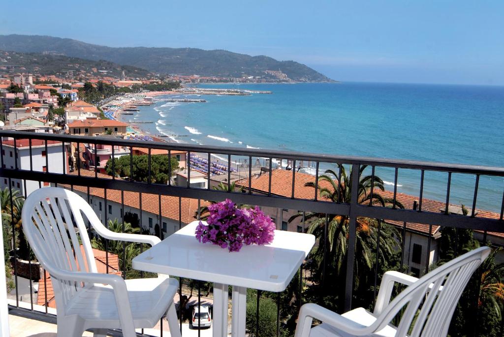 une table et des chaises sur un balcon avec vue sur la plage dans l'établissement Piccolo Hotel, à Diano Marina