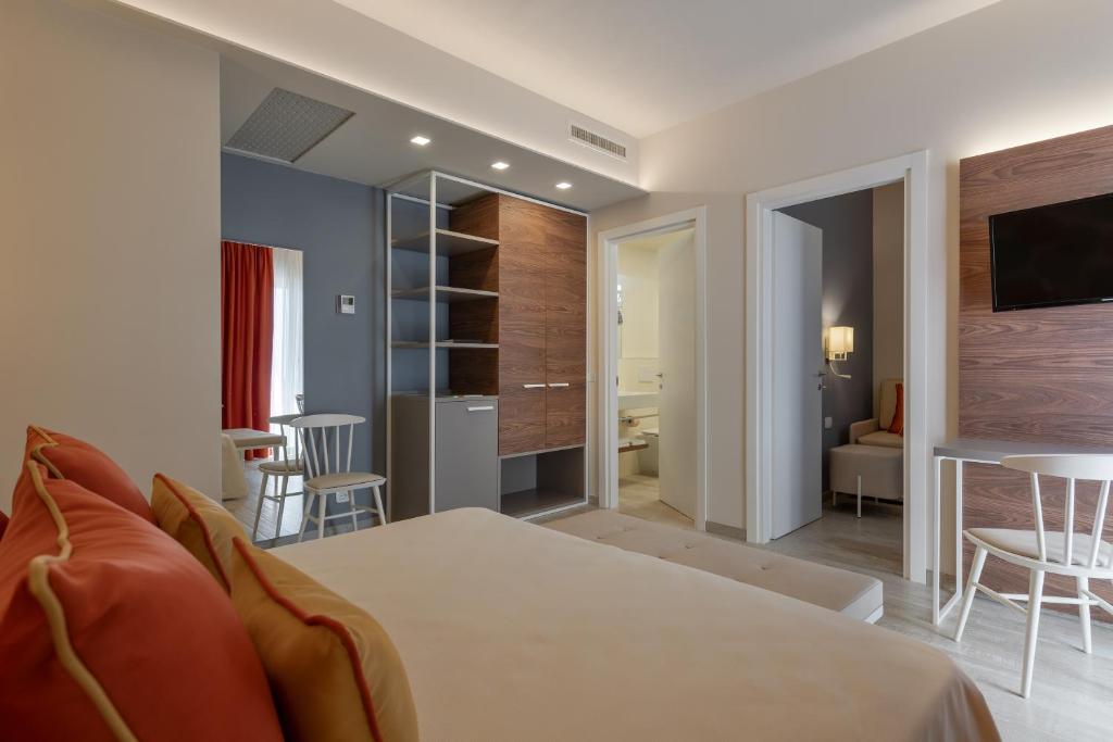 une chambre avec un lit et un salon dans l'établissement Hotel Victoria, à Bibione