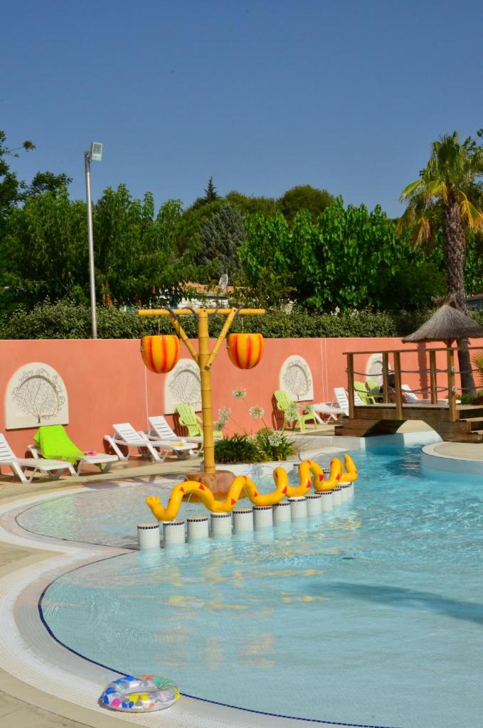 une piscine avec un arbre au milieu dans l'établissement Domaine Sainte Veziane, à Bessan