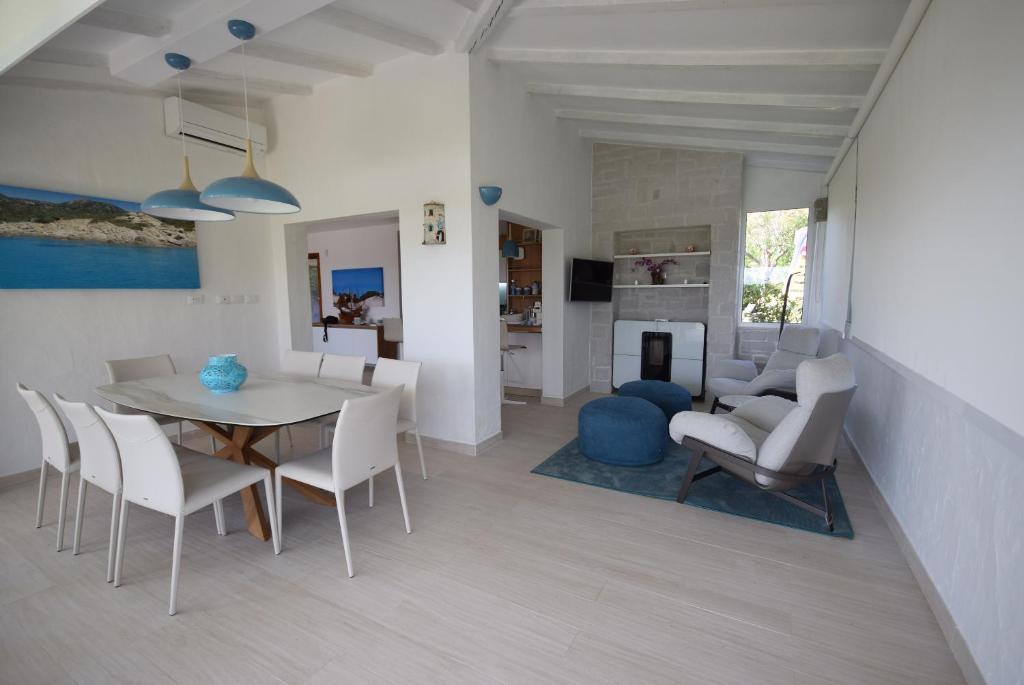 une salle à manger et un salon avec une table et des chaises dans l'établissement VILLA BAIRES - CHIA, à Domus de Maria