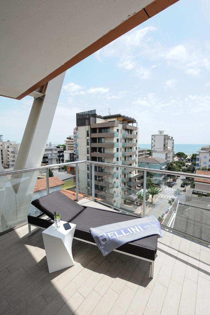 un balcon avec un banc et une vue sur une ville dans l'établissement Bellini Relais, à Lignano Sabbiadoro