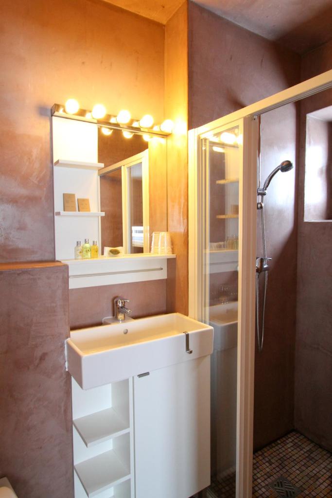 une salle de bain avec un lavabo et un miroir dans l'établissement le Chal'heureux, à Vars