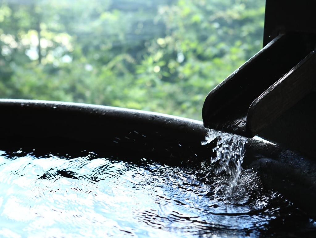 un bain d'oiseaux avec de l'eau qui en sort dans l'établissement Yoshinotei, à Iida