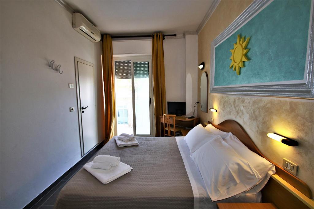 une chambre avec un lit avec deux serviettes dessus dans l'établissement Hotel De Amicis, à Riccione