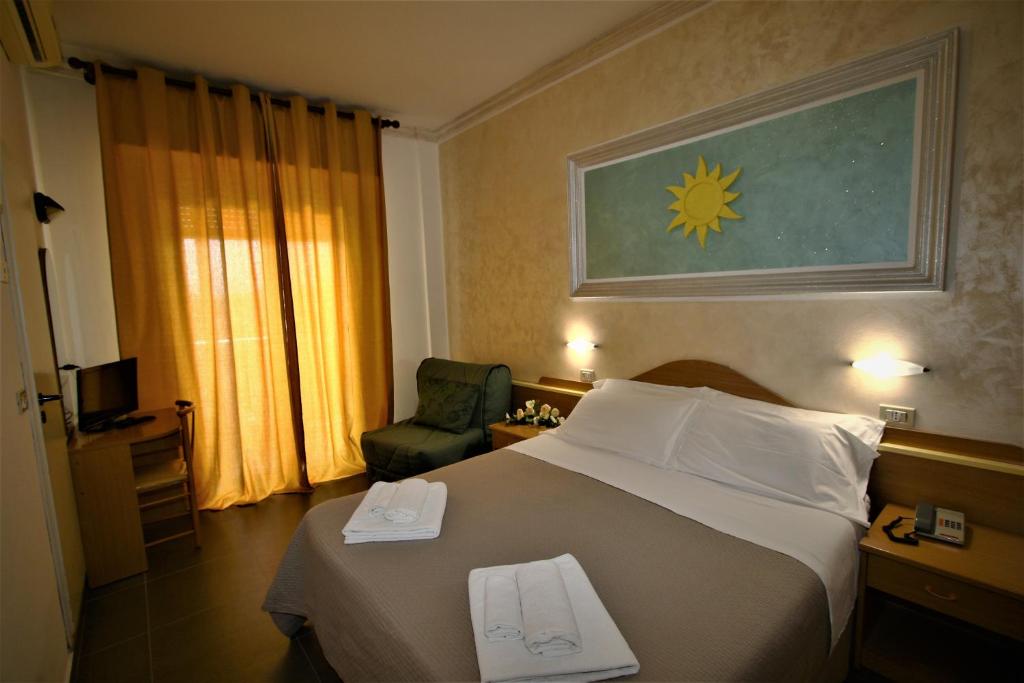 une chambre d'hôtel avec un lit et une chaise dans l'établissement Hotel De Amicis, à Riccione 59 autres photos