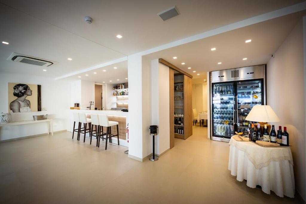 Cette chambre dispose d'un bar avec une table et des bouteilles de vin. dans l'établissement International Beach Hotel, à Caorle