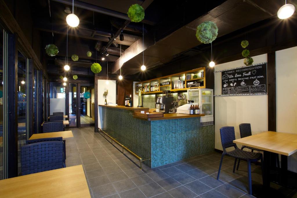 un restaurant avec un bar, des tables et des chaises dans l'établissement Koyado Enn, à Toyooka
