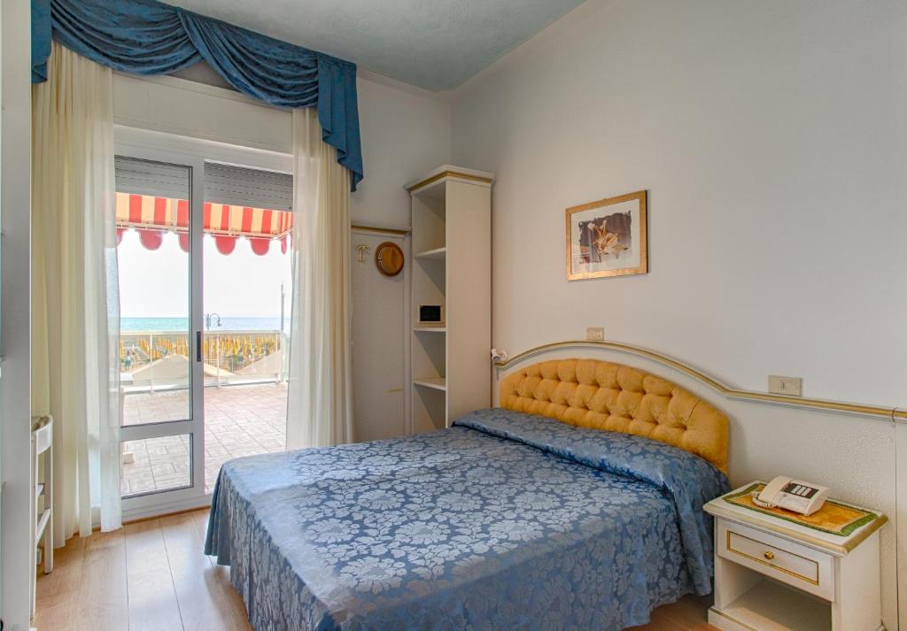 une chambre avec un lit et une grande fenêtre dans l'établissement Hotel Panama, à Lido di Jesolo