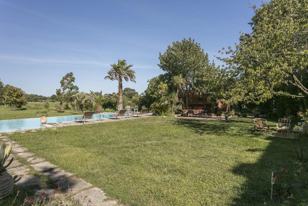 un grand jardin avec une piscine et des arbres dans l'établissement Domaine Sesquier Mas d'exception Acacia, à Mèze