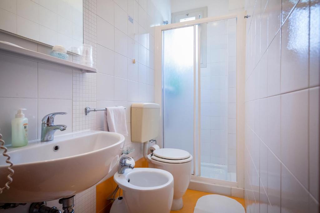 une salle de bain avec un lavabo, des toilettes et une douche dans l'établissement Hotel Verona, à Caorle 44 autres photos
