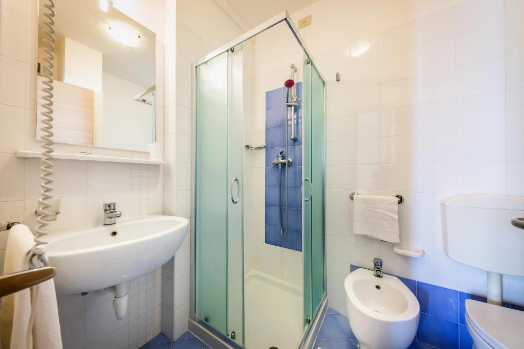 une salle de bain avec un lavabo et une douche en verre dans l'établissement Hotel Verona, à Caorle