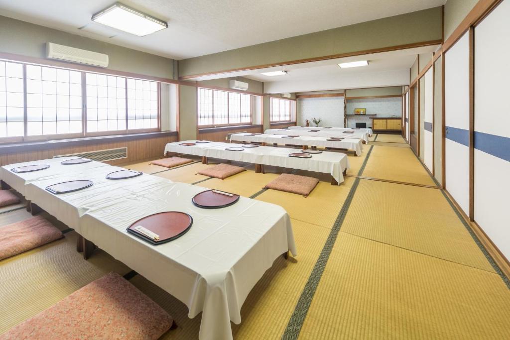 une rangée de tables dans une grande pièce avec fenêtres dans l'établissement Shoei Daini Bekkan, à Kōchi