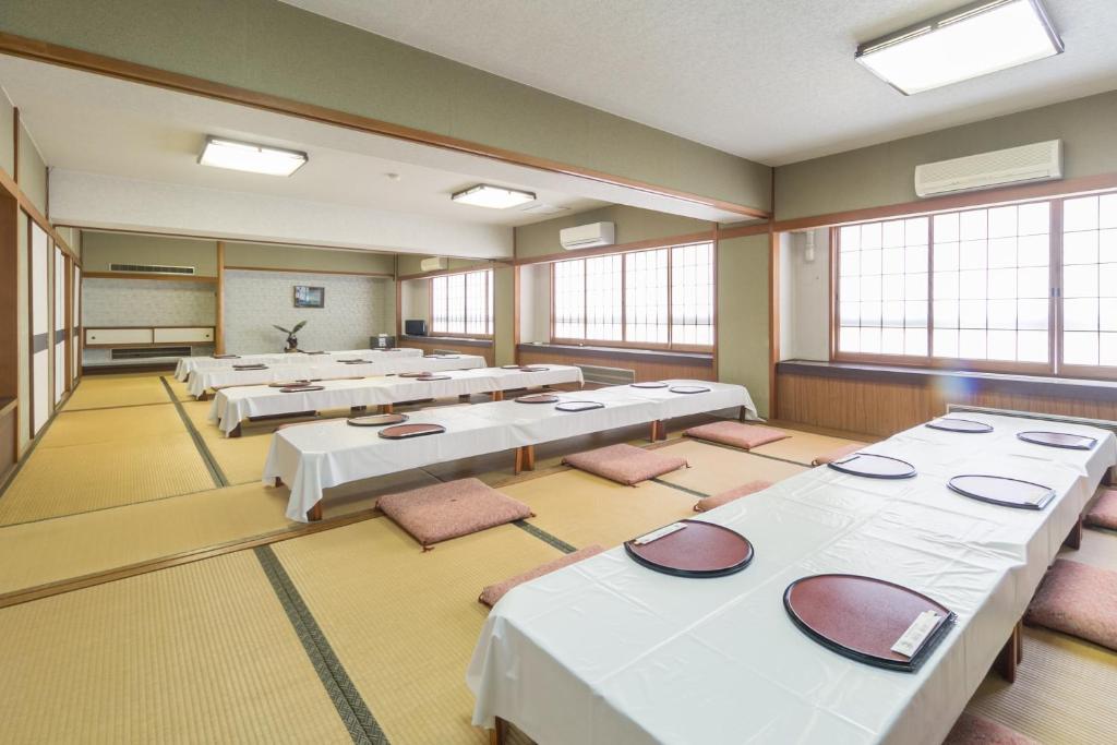 une grande pièce avec des tables, des chaises et des fenêtres dans l'établissement Shoei Daini Bekkan, à Kōchi 37 autres photos