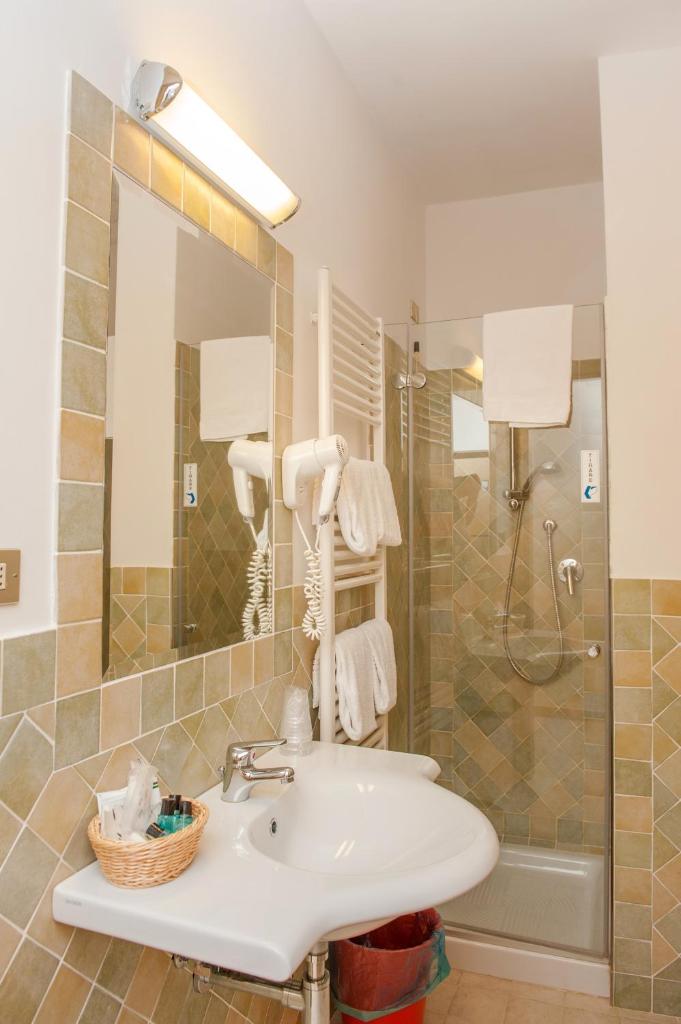 une salle de bain avec un lavabo et une douche dans l'établissement Hotel Cristalda, à Vieste