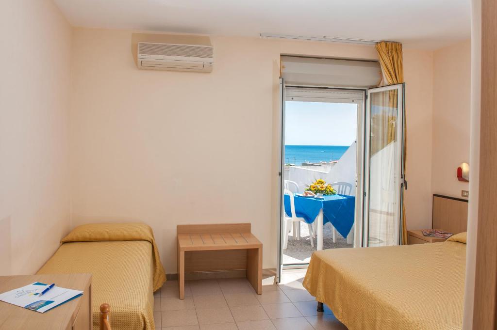 une chambre avec deux lits et une vue sur l'océan dans l'établissement Hotel Cristalda, à Vieste