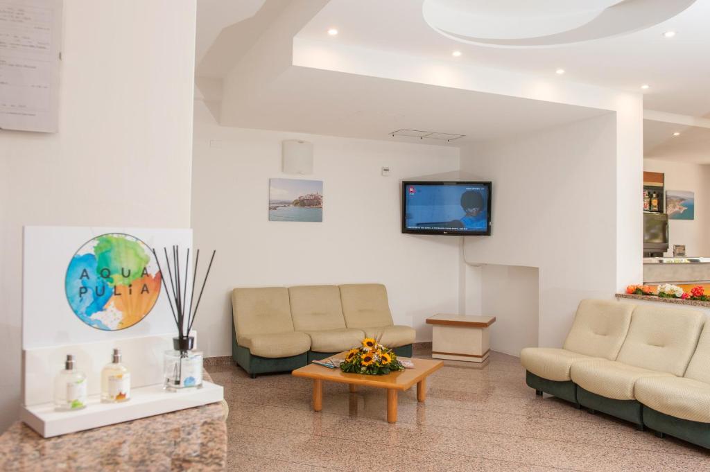 un salon avec deux canapés et une télévision dans l'établissement Hotel Cristalda, à Vieste