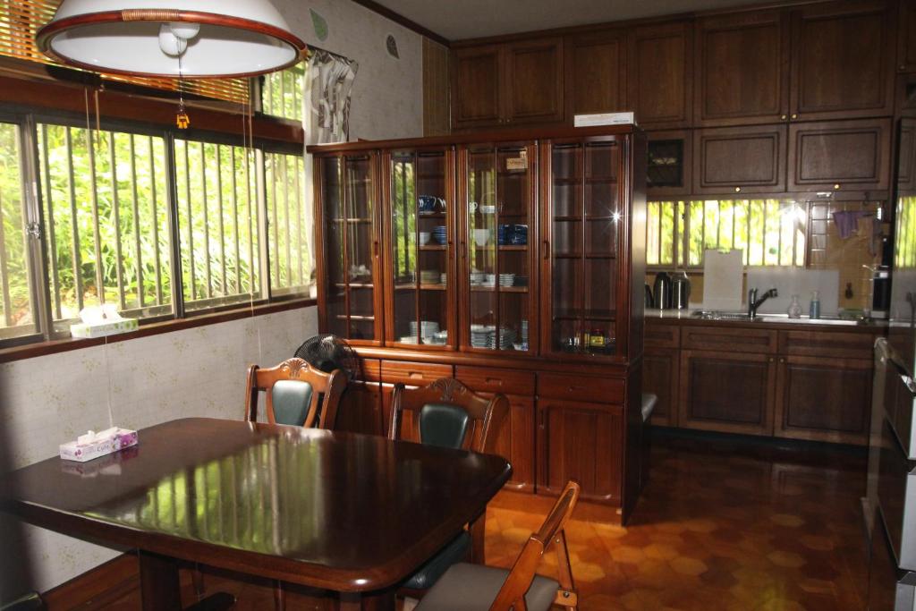 une cuisine avec une table, des chaises et des fenêtres dans l'établissement Kougetsu Sanso -- Moon Villa in Tokyo, à Hachioji