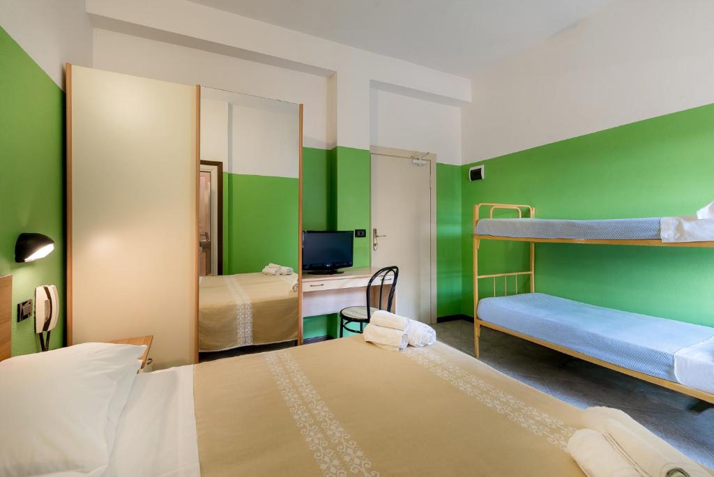une chambre avec deux lits superposés aux murs verts dans l'établissement Hotel T Depandance, à Rimini
