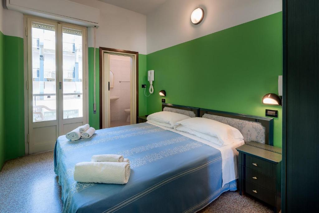 - une chambre avec un lit bleu aux murs verts dans l'établissement Hotel T Depandance, à Rimini