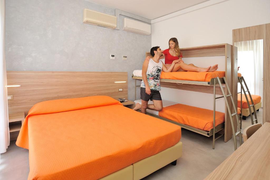 deux personnes debout dans une pièce avec deux lits dans l'établissement Hotel Lidia, à Alba Adriatica 45 autres photos