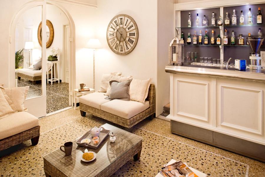 un salon avec un canapé et une horloge au mur dans l'établissement Hotel Gabbiano, à Alassio