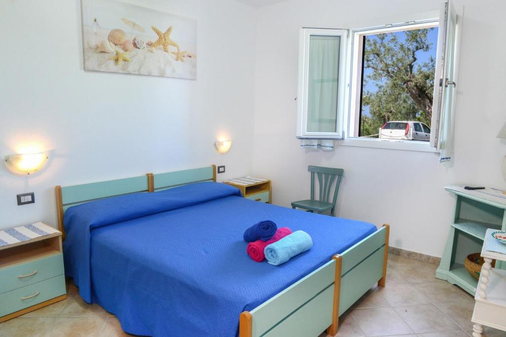 - une chambre dotée d'un lit bleu avec un ours en peluche rouge dans l'établissement villa la Scaletta, à Alghero 41 autres photos