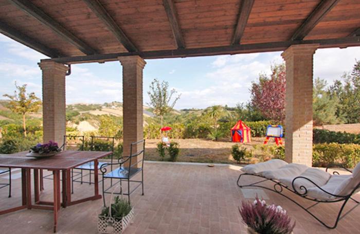 une terrasse avec une table et des chaises ainsi qu'une tente dans l'établissement Casali Costadoro, à Acquaviva Picena