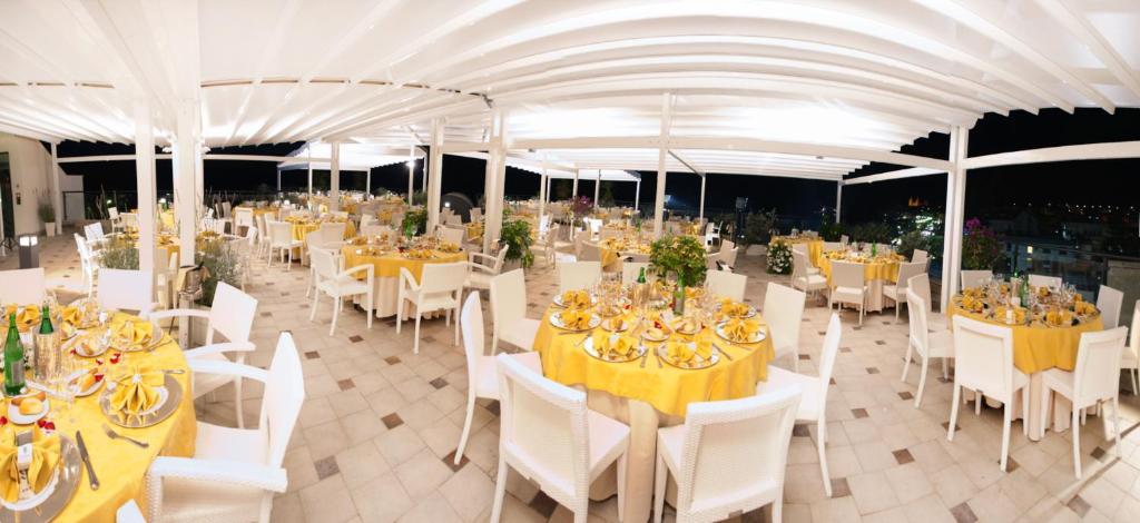 une salle de banquet avec des tables blanches et des chaises blanches dans l'établissement Cefalù Sea Palace, à Cefalù 105 autres photos