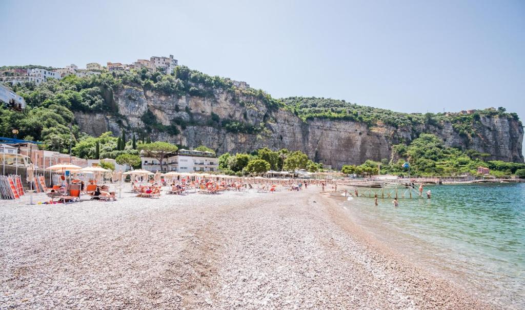 une plage avec une foule de gens et l'eau dans l'établissement Hotel Le Axidie, à Vico Equense