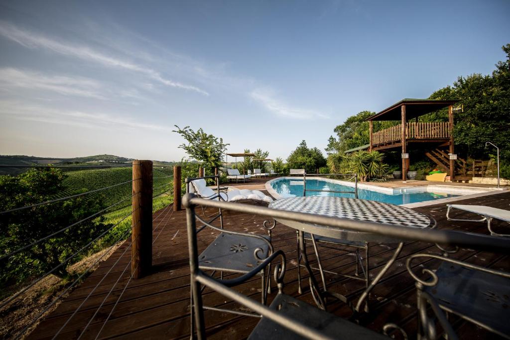 une terrasse avec des chaises et une piscine dans l'établissement Casali Costadoro, à Acquaviva Picena