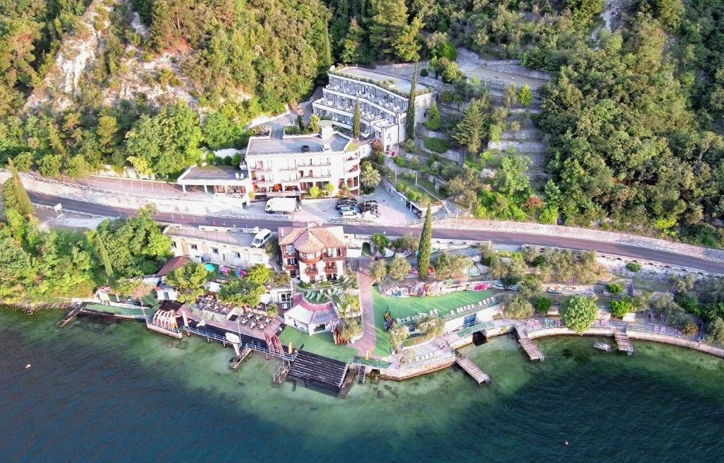 une vue aérienne sur une grande maison sur l'eau dans l'établissement Surf Hotel Pier - Montagnoli Group, à Limone sul Garda