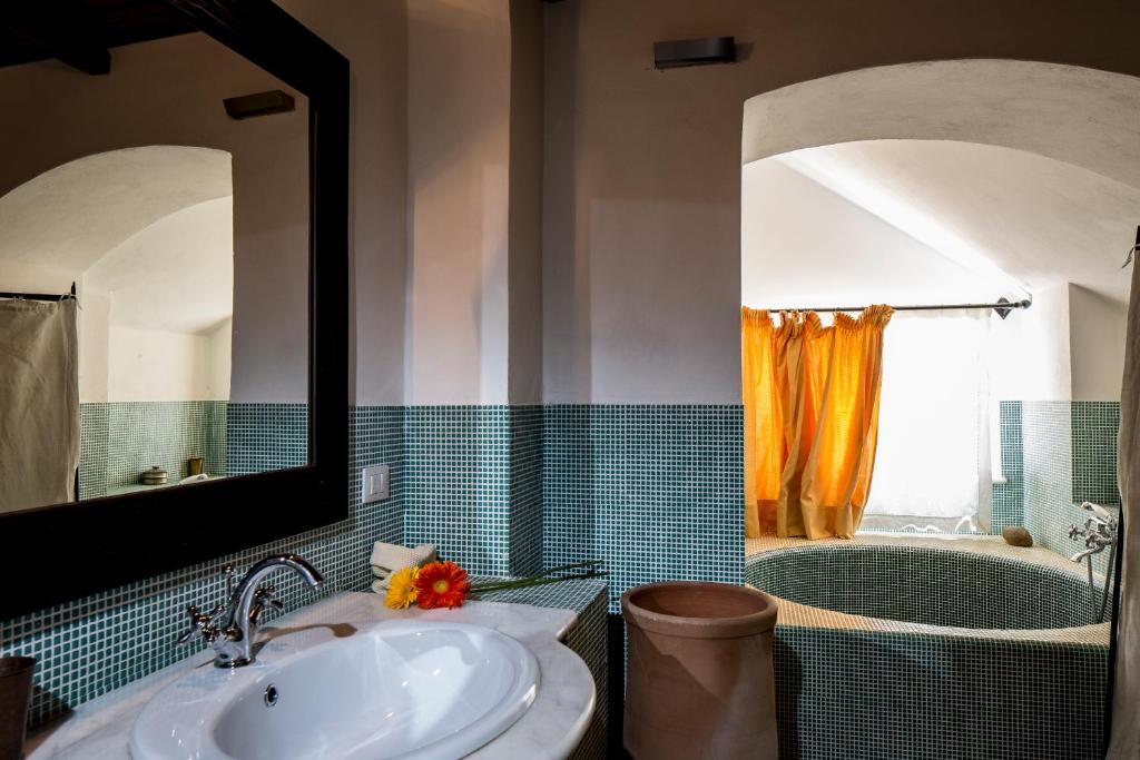 La salle de bains est pourvue d'un lavabo et d'une baignoire avec un miroir. dans l'établissement Casali Costadoro, à Acquaviva Picena