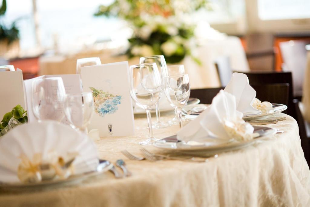 - une table avec des verres à vin et des serviettes dans l'établissement Hotel Savoia, à Alassio