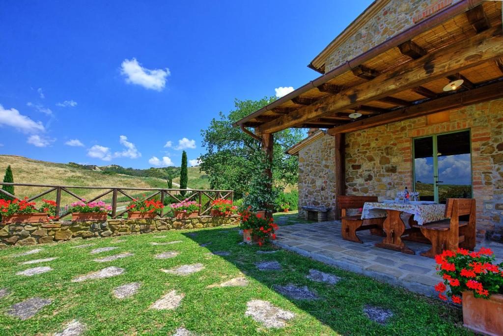 une maison en pierre avec une table de pique-nique dans une cour dans l'établissement Castelmuzio by PosarelliVillas, à Castelmuzio