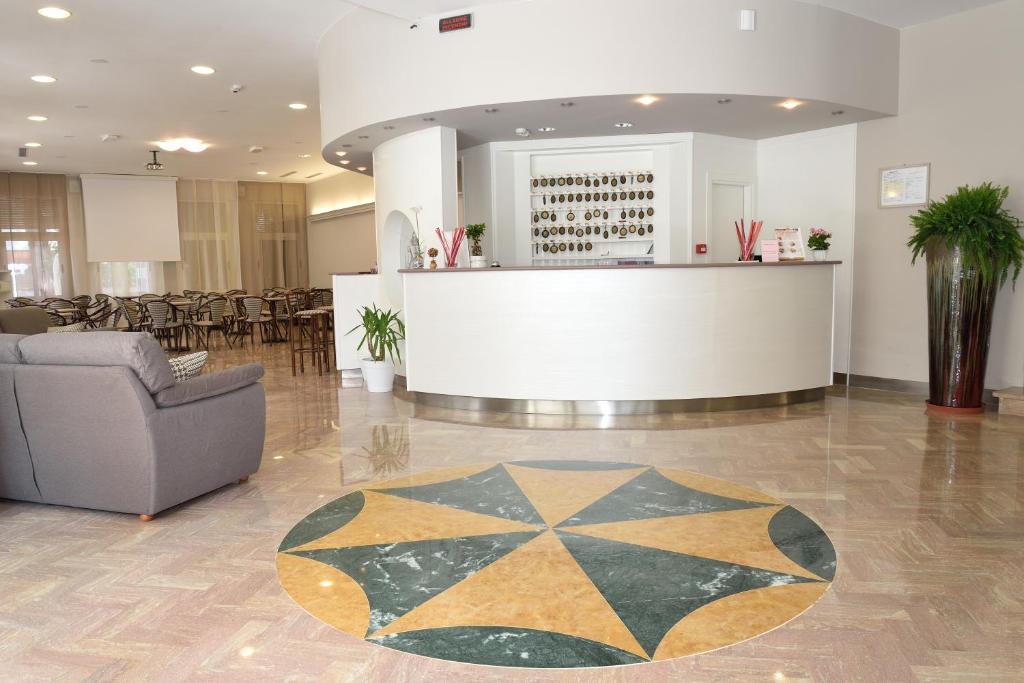 - un hall avec un comptoir, une chaise et une table dans l'établissement Hotel San Giorgio, à Milano Marittima