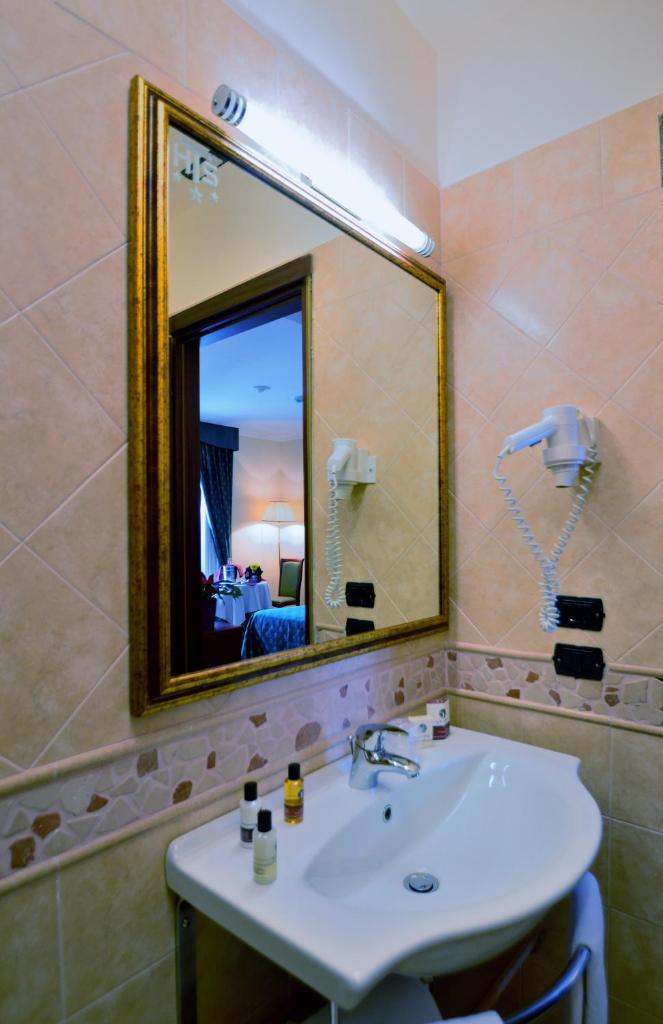 une salle de bain avec un lavabo et un miroir dans l'établissement Hotel Tito Serrano', à Melito di Porto Salvo