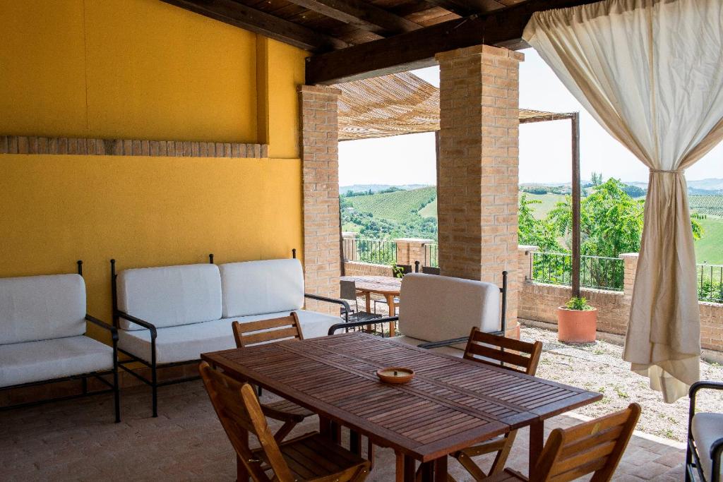 un salon avec une table et des chaises en bois dans l'établissement Casali Costadoro, à Acquaviva Picena
