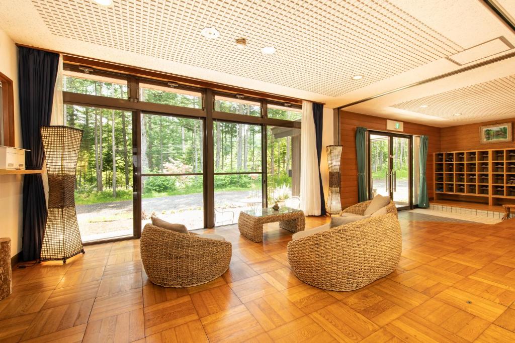 - un salon avec des chaises et une grande fenêtre dans l'établissement Yamanaka Lake Ryozan, à Yamanakako