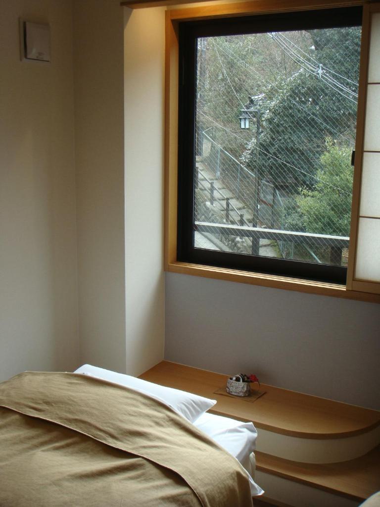 une chambre avec un lit et une fenêtre dans l'établissement Mizuhasou, à Miyajima