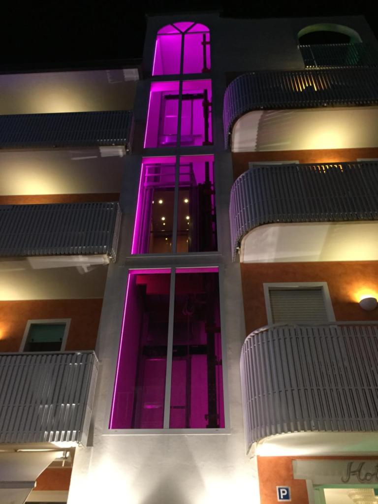 Un bâtiment avec des lumières violettes sur son côté dans l'établissement Hotel Erika, à Caorle