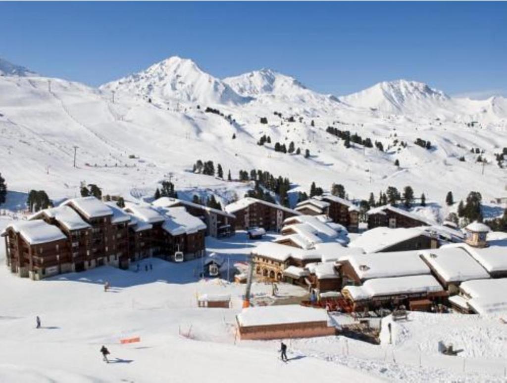 une station de ski avec des bâtiments enneigés sur une montagne dans l'établissement Résidence Pierre & Vacances Emeraude, à Belle Plagne