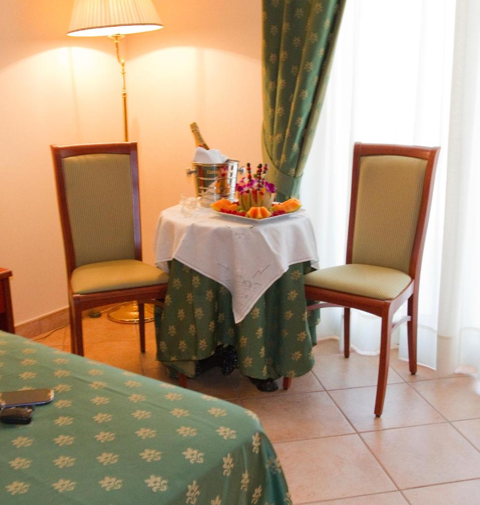 une table avec des fruits dessus avec deux chaises dans l'établissement Hotel Tito Serrano', à Melito di Porto Salvo 15 autres photos