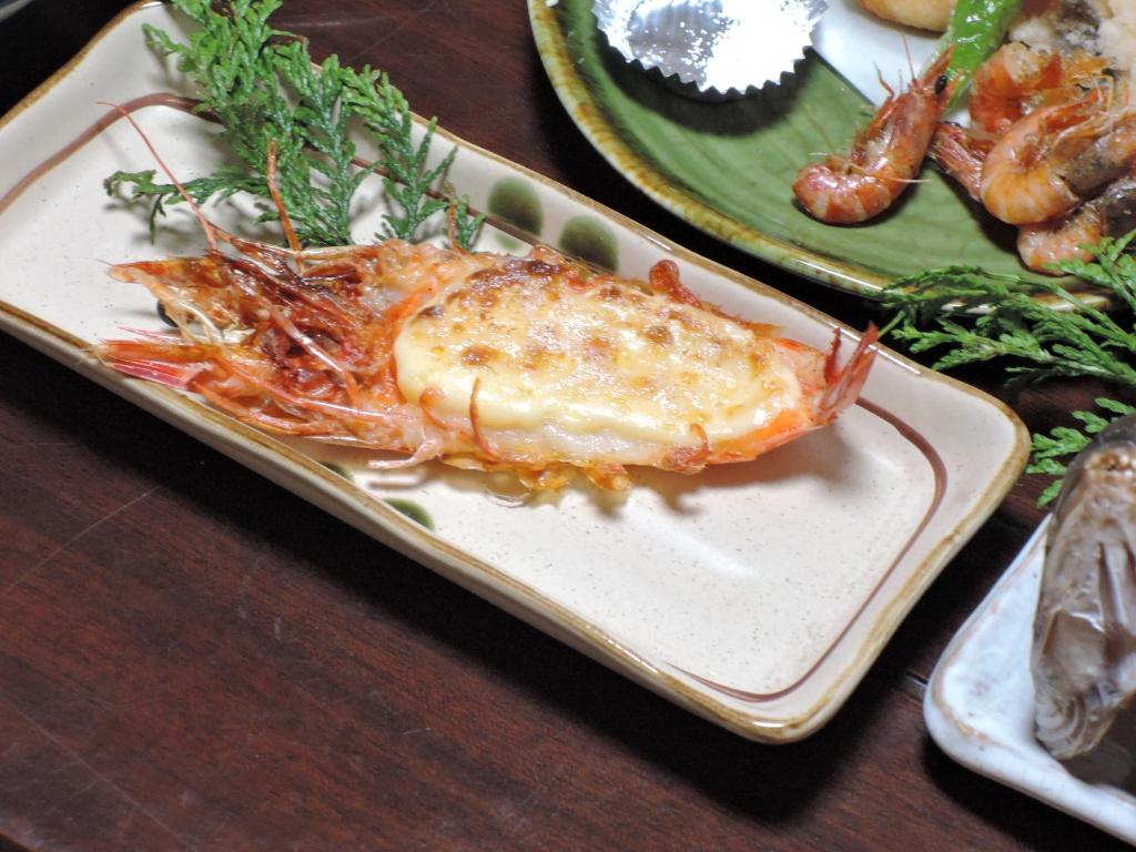 une assiette de nourriture avec un homard sur une table dans l'établissement Minshuku Osaki, à Nishio