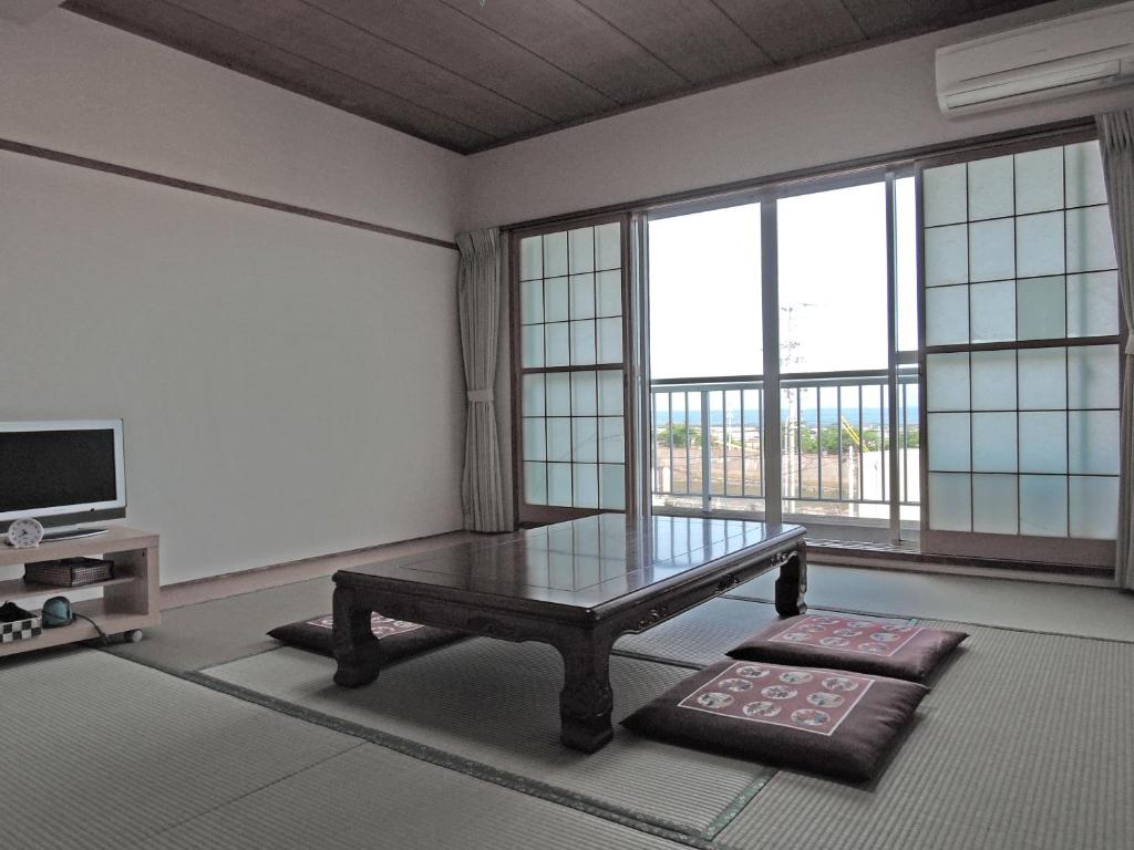 - un salon avec une table basse et de grandes fenêtres dans l'établissement Minshuku Osaki, à Nishio 37 autres photos