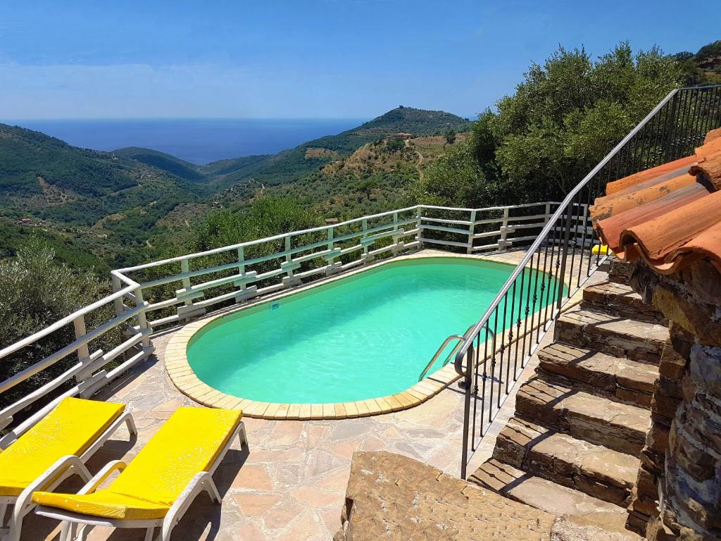 - une piscine avec 2 chaises jaunes à côté d'une colline dans l'établissement Il Canale 1861, à San Mauro Cilento