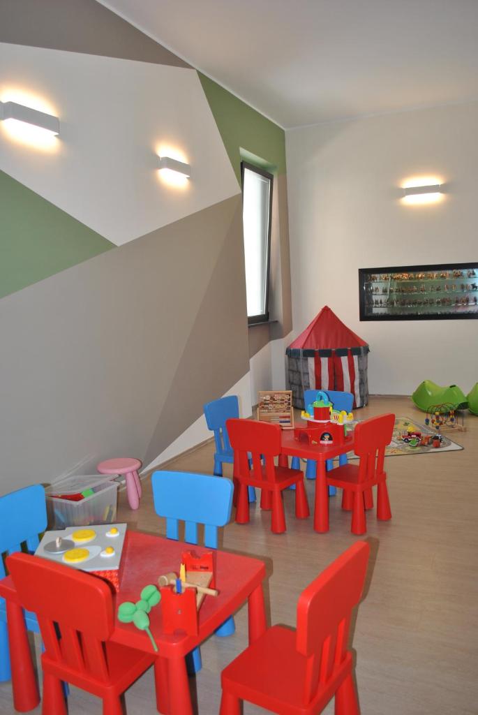 Cette chambre comprend des tables et des chaises rouges et bleues. dans l'établissement Hotel Residence Laigueglia free parking, à Laigueglia 40 autres photos